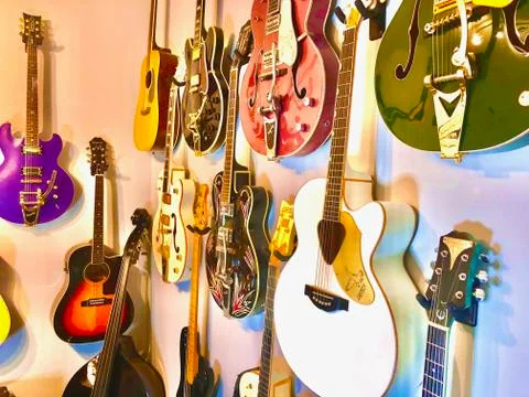 Guitars hanging on wall Foto stock