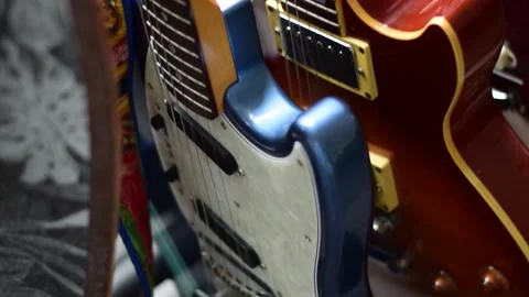 Guitars in a stand with a skateboard Stock Footage 134384178