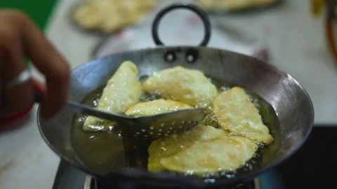 Gujhiya a dessert being crispy fried in oil Stock Footage 304196330