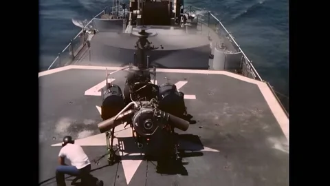 GULF OF TONKIN - 1967 - Deck hands chain down a Drone Anti-Submarine Helicopter Stock Footage 296690105
