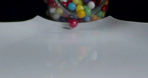 Gumballs spilling onto white platter in reverse shot. Close-up of colorful balls Stock Footage 169775315