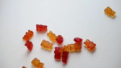 Gummy Bears falling onto a white table. Sweet gummy bears Isolated on white back Stock Footage 287732752