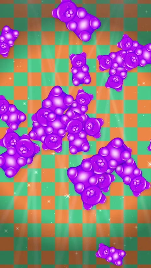 Gummy Bears Floating Over Green and Orange Checkerboard Background Stock Footage 344931864