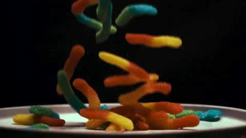 Gummy Worms Fall on Dinner Plate Stock Footage 300892600
