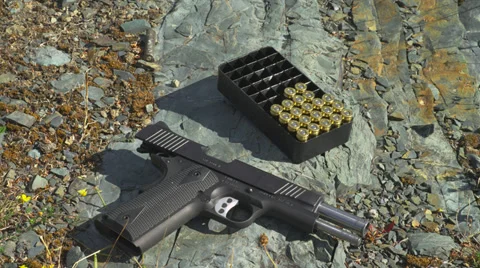 Gun and Bullets on Rock Stock Footage 35285440