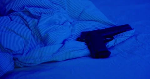 A gun on a bed dark Video stock 308682726