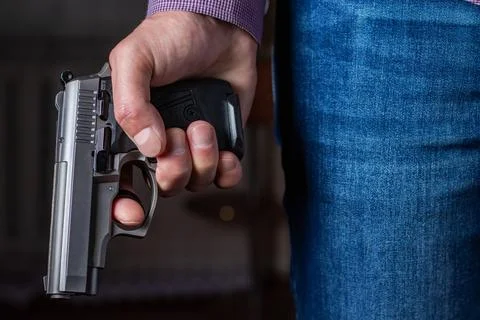 Gun control concept. Armed man holds pistol in hand Stock Photos