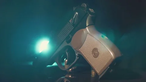 Gun lies on the slowly rotating surface. Highlighted with by light Stock Footage 71061990