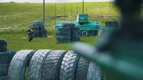Gun shoots paint balls while playing paintball Stock Footage 116246326