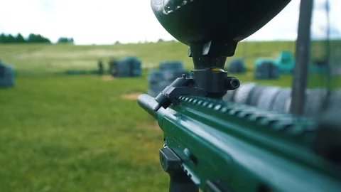 Gun shoots paint balls while playing paintball Stock Footage 118360090