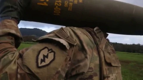 The gunner carries a 155mm HE shell on his shoulder Stock Footage 120830188