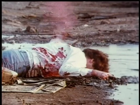 Gunshots hitting bleeding man on ground Stock Footage 260247195