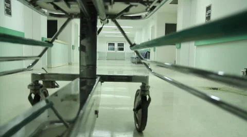 Gurney being pushed down an empty hospital hallway into Restricted area HD video Stock Footage