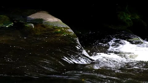Gushing river flows into waterfall - Slow Motion Stock Footage 244181057