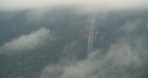 Gushing waterfall on a rainforest cliff face in a rainstorm, Ecuador Stock Footage 147747413