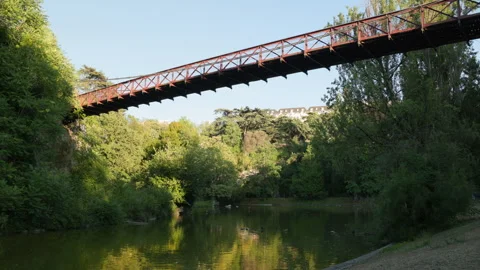 Gustave Eiffel Suspension Bridge Over Lake at Parc des Buttes-Chaumont in Paris Stock Footage 338383406
