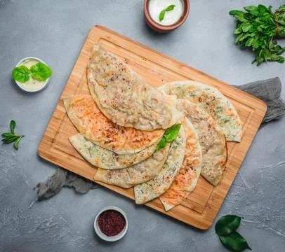 Gutab flatbread stuffed with meat and fresh herbs on wood board Stock Photos