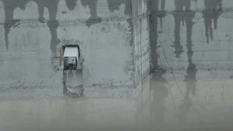 A gutter in the rain protrudes from the concrete Stock Footage 130171195