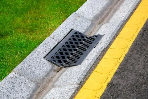 Gutter of a stormwater drainage system on the side of an road. Stock Photos