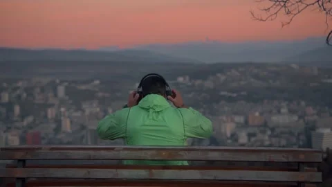 The guy after morning run siting and calm down with a great sunrise view . Stock Footage 239552103