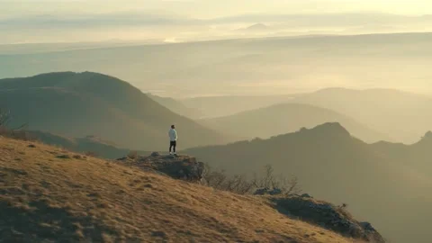 The guy after morning run standing and calm down with a great sunrise view . Video stock 239551336