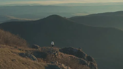 The guy after morning run standing and calm down with a great sunrise view . Video stock 239551348