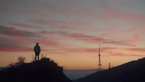 The guy after morning run standing and calm down with a great sunrise view . Stock Footage 239551652