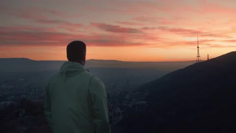 The guy after morning run standing and calm down with a great sunrise view . Video stock 239551658