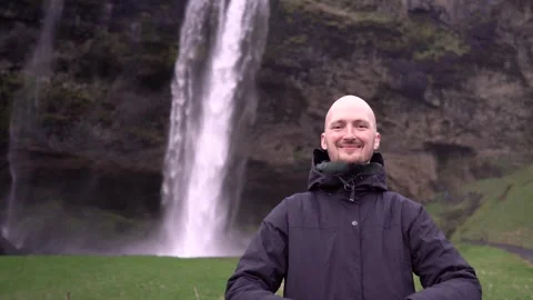 Guy against the backdrop of a waterfall in Iceland Stock Footage 257208328