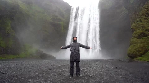 Guy against the backdrop of a waterfall in Iceland Stock Footage 257208381