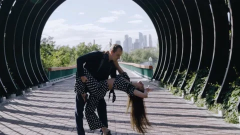 A guy and a girl are dancing in a park in the city Stock Footage 201969495