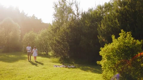 A guy and a girl are walking near their picnic spot Stock Footage 250484553
