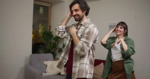 Guy and a girl dance a synchronized dance and prepare for a flash mob at home in Stock Footage 318079462