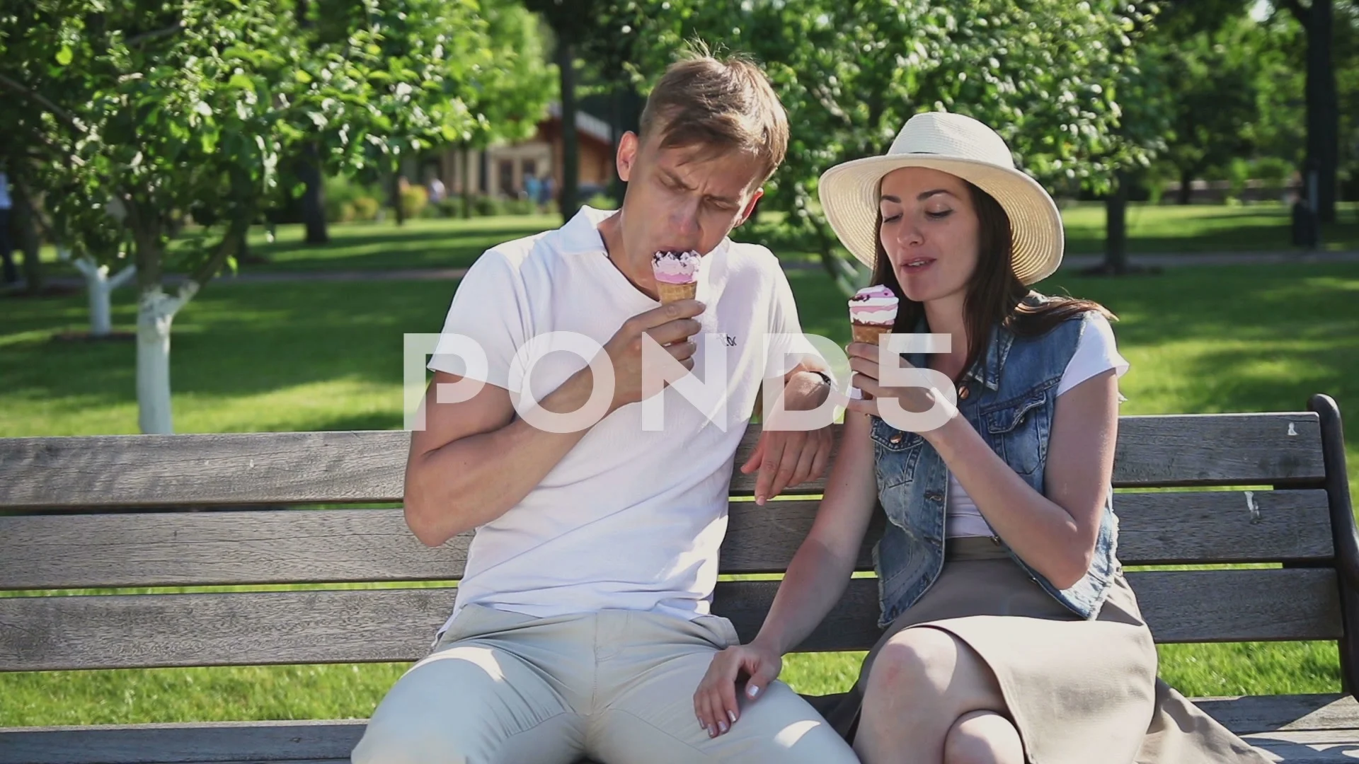 Guy and girl eating an ice cream in the park