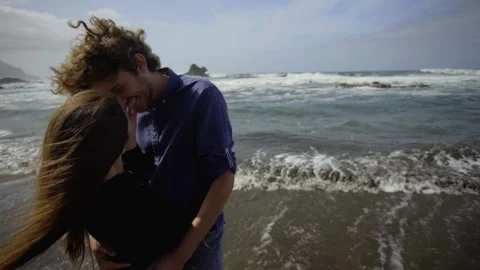 A guy and a girl hug against the background of the waves. Happy couple at sea. Stock Footage 229963243