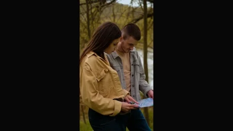 A guy and a girl with a map in hand in the forest. Navigation apps, geolocation Stock Footage 271556763