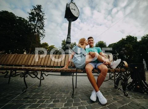 Guy and girl sitting on a bench Stock Photos