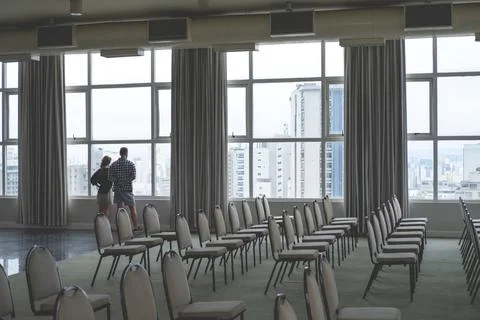 A guy and a girl at the window in an empty conference room of the hotel Stock Photos