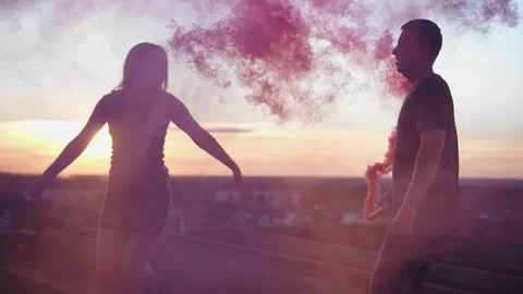 A guy and his girlfriend are waving checkers with colored smoke Stock Footage 304997504