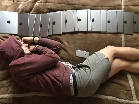 A guy and a lot of electronic tablets. A man fell asleep near a smartphone an Stock Photos