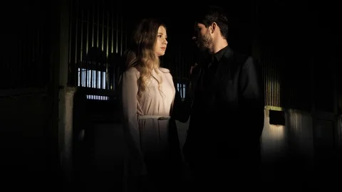 Guy and pretty lady stand in silence under electric light Stock Footage 105935220