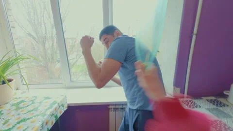 The guy angered his girlfriend and she jokingly beat him with a plastic bottle. Video stock 332284838