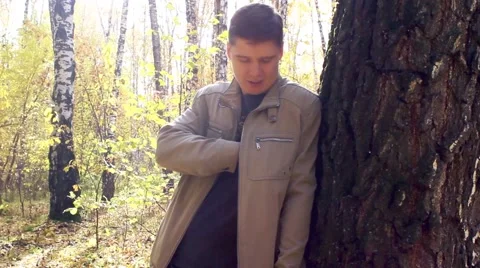 The guy answers the phone in the forest Video stock 56765119