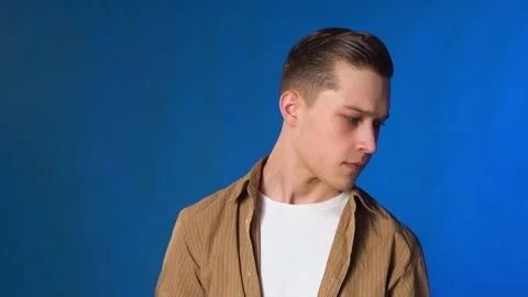 Guy appears and leaves frame playing guitar, on blue background 스톡 동영상 132893959