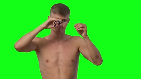 Guy athletic body without a t-shirt funny cuts his own hair.Green screen Vidéo 239661972