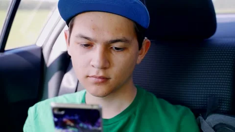 The guy in the back seat of a car with a smartphone in his hands. Stock Footage 139743615