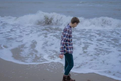 Guy on the background of big sea waves Stock Photos