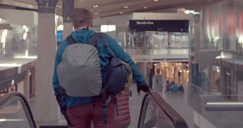 A guy with a backpack and a bag goes down the escalator in the building  Stock Footage 119596219