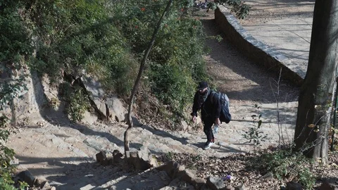 The guy with the backpack climbs the steep stairs in the forest Barcelona Stock Footage 101269582