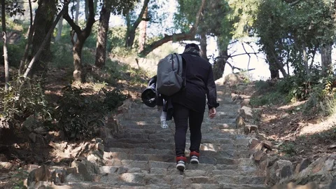 The guy with the backpack climbs the steep stairs in the forest Barcelona Stock Footage 101269721